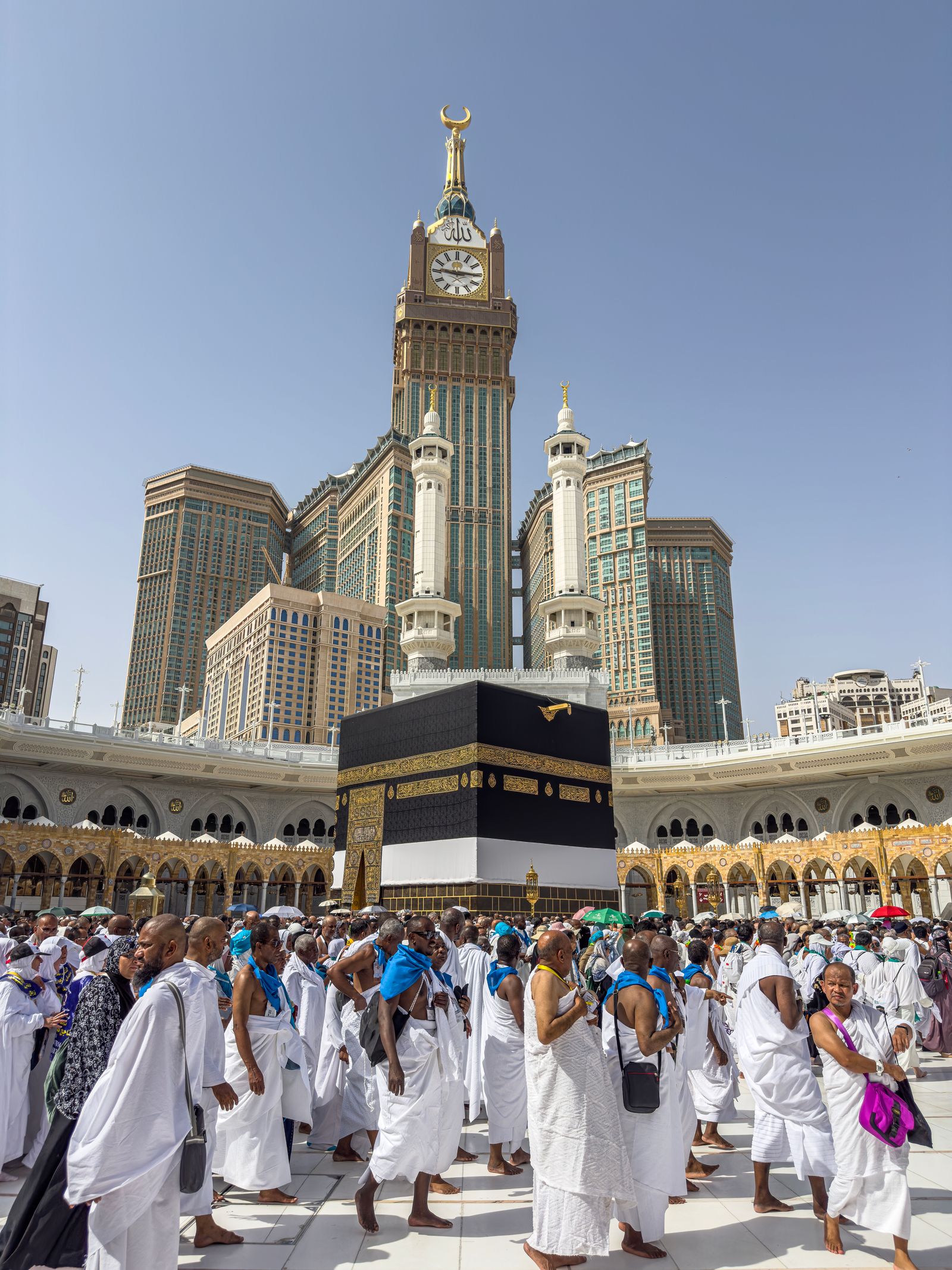 Pilgrims in ihram walking near the Kaaba in Makkah.