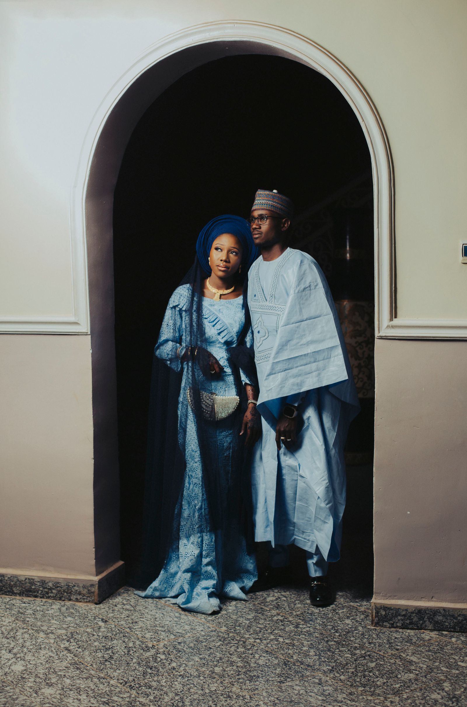 A bride and groom in matching blue traditional attire.